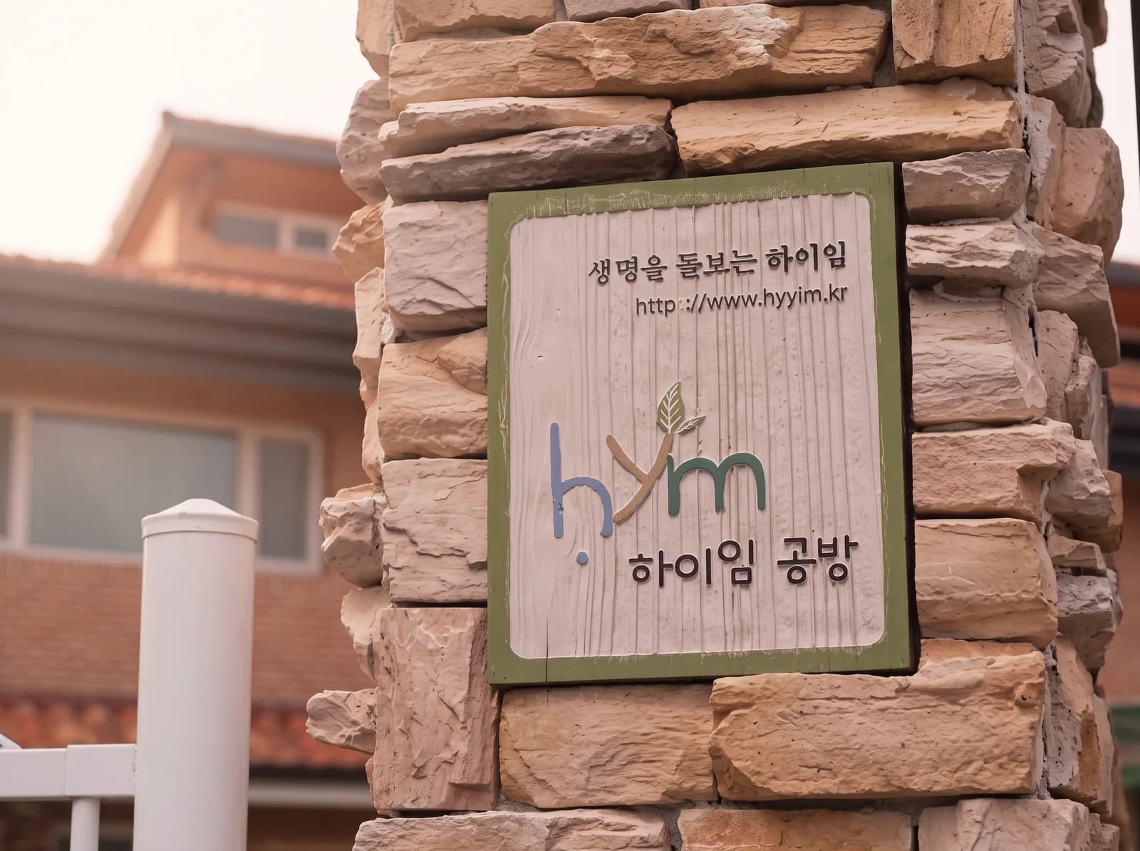 돌기둥에 박힌 ‘생명을 돌보는 하이임 · 하이임 공방’ 나무 간판